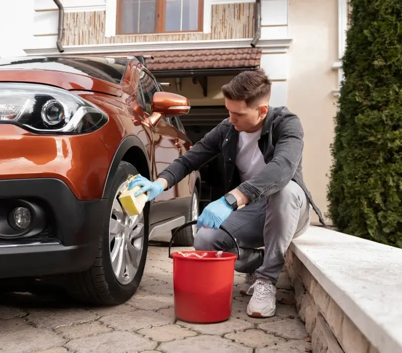 Lavage auto à domicile Vallon-Pont-d'Arc : professionnel intervenant sur un véhicule